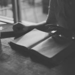 Someone reading a book on a table.